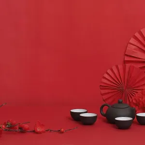 Fondo rojo simple con una tetera y tazas.