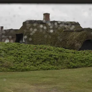 Vue à travers une fenêtre avec des gouttelettes de pluie floues.