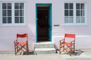 Drucke von Benwick Cottage am Marine Promenade in Lyme Regis im Dorset. Zwei rote Faltenstühle stehen außerhalb der offenen Vordertür von Benwick Cottage Architektur in England – Historische und moderne Gebäude: Kottenhaus Tür EFC01 01 05 026 60353
