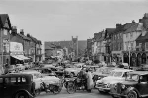 Drucke von Henley-on-Thames, Oxfordshire. Die Sicht vom Marktplatz Richtung Hart Street mit Autos im Vordergrund und dem Turm der St-Marys-Kirche im Hintergrund fotografiert im März 1958 von Andor Gomme Verkehr und Wasserstraßen in England – Eisenbahnen, Kanäle und Straßen: Henley-on-Thames, GOM 01/05/06 8