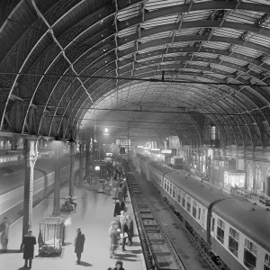 Drucke von Paddington Bahnhof, London. Aufgelöste Ansicht zeigend Passagiere auf der Warteschlange für den Zug an der Plattform 2 im Paddington Eisenbahnbahnhof Verkehr und Wasserstraßen in England – Eisenbahnen, Kanäle und Straßen: Paddingtons Bahnhof 06/19/37