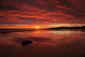 Die dramatische Sonnenaufgang von Dunstanburgh