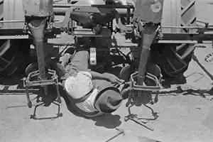 American Rural Landscape Drucke: Adjusting plow points on tractor-drawn planter, large farm n