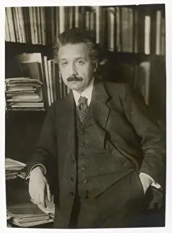 Drucke von Albert Einstein (1879-1955), theoretischer Physiker, Philosoph und Autor. Hier vor Bücherregalen steht er Albert Einstein Drucke: Albert Einstein, theoretischer Physiker