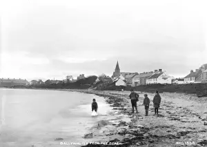 Drucke von Ein Blick auf den Strand bei Fairhead, Ballycastle - ein Ausblick entlang der Küste mit Gebäuden zu Fairhead stehen Menschen am Sand. (Standort: Nordirland, Grafschaft Antrim, Ballycastle) Ballycastle Drucke: Ballywalter am Strand