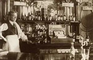 Der Barkeeper steht neben dem gut ausgestatteten Tresen