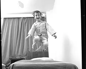 Junge springt auf und ab auf einem Bett