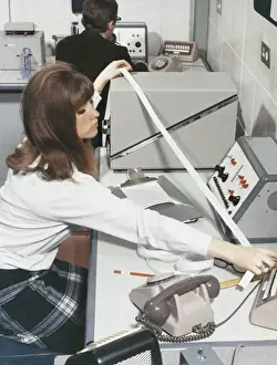 Technician At Work Drucke: A computer technician with data tape