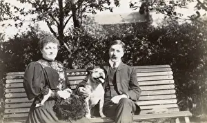 Man And Woman Sitting Together Drucke: Couple on a bench with a dog