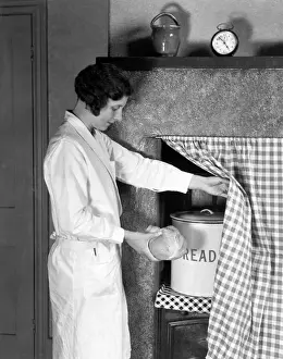 Drucke von Ein Vorhang hing über einer nicht mehr genutzten Backofen ist eine diskrete Möglichkeit, deinen Brotkorb im Brotbin zu lagern. Datum: 1930er Jahre Küche Drucke: Diskrete Brotkorb