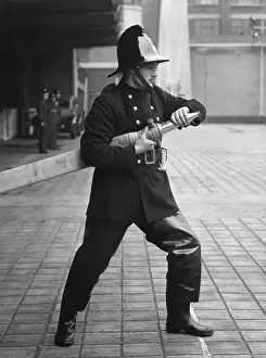 Historical Firefighting Equipment Drucke: Firefighter taking part in a hose training drill