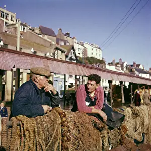 Coastal Towns In England Drucke: Two fishermen in Brixham Harbour, Devon