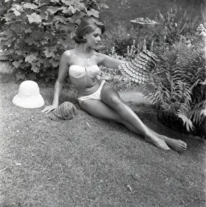 Modell sonnt sich im weißen Bikini aus