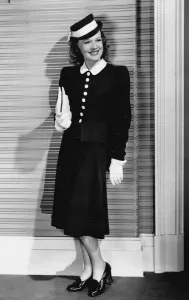 Drucke von Ein schwarzes Wolfschafrock, entworfen von Dolly Tree, wurde in The Golden Fleecing (1940) von Rita Johnson getragen. Das Kleid war bei den Hüften eng gefittet und flach am Rande ausgeschnitten Rita Drucke: Ein schwarzes Wolfsfell-Anzug entworfen von Dolly Tree