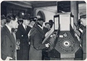 London Underground History Drucke: Photograph showing a queue of passengers waiting to use the new mechanical informator at Charing Cross Underground