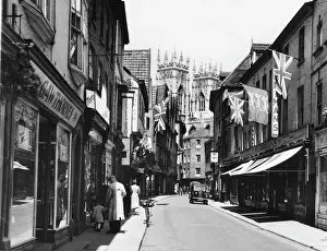 Drucke von Ein Blick auf die Petersgasse zu Festzeit in York mit dem Turm der Kathedrale im Hintergrund York Drucke: Petergate in York