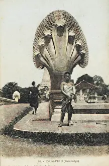 Drucke von Ein Junge stand vor einer bemerkenswerten Statue in Phnom Penh, Kambodscha, eines siebenköpfigen Kobra-Schlangen, die einen Brücke im Palastkomplex bewacht Cobra Drucke: Phnom Penh, Kambodscha
