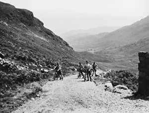 Drucke von Radfahrer auf Touren und Wanderer unterwegs. Sie machen einen Pausenpause beim steilen und rauhen Ritt über den Wrynose-Pass in einem der wildsten Teile des Tal von Langdale im Westmorland, England Westmorland Drucke: Waldfahrer auf dem Rynose-Pass