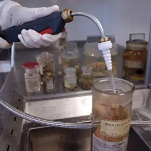 Science Laboratory Equipment Drucke: Scientist at work adding alcohol to a specimen jar