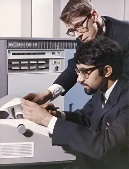 Heinz Zinram Photography Drucke: Two technicians check a computer printout