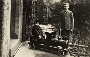 Railway Nostalgia Drucke: Young boy in a model train with his elder brother