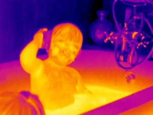 Drucke von Kind im Bad mit Thermagramm-Bild. Die Farben zeigen Temperaturenveränderungen ab. Das Skalensystem läuft von Weiß (wärstes), durch Gelb, Orange, Rot und Violett bis hin zu Blau (kältestes) Bilder Datiert 2004 März: Kinder im Baden