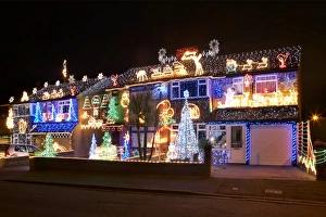 Drucke von Weihnachtslichter vor einer Reihe von Häusern, die mit Weihnachtsglühbirnen und Dekorationen geschmückt sind, am Abend Bilder Datiert 2009 September: Weihnachtslichter