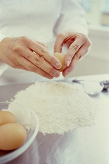 Drucke von Eier und Mehl. Hände ein Ei in das Mehl hinzufügen. Diese Mischung kann dann verwendet werden, um eine breite Palette von Lebensmitteln herzustellen, vom Kuchen bis zum Brot und Backwaren zu machen Bilder Datiert 2003 Juni: Ei und Mehl