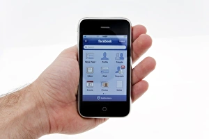 Hand Holding Smartphone Drucke: IPhone with facebook display