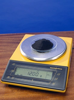 Drucke von Ein Mole Kohlenstoff. Kohlendunst wird auf einem Gleichgewichtsgerät abgewogen. Zwölf Gramm Kohlenstoff entsprechen einem Mole Bilder Datiert 2004 Februar: Ein Molekül Kohlenstoff