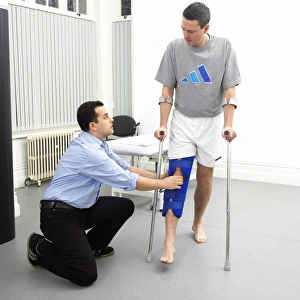 Drucke von MODELL FREIGEBEN. Physischtherapie. Der Physiatherapeut bewertet die Mobilität im Gelenk eines Patienten. Der Patient trägt eine Brille zum Festhalten des Beins nach einer Verletzung Bilder Datiert 2006 Januar: Physiotherapy