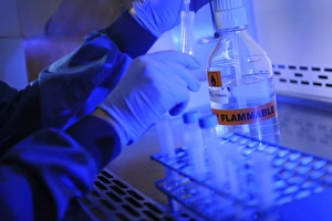 Scientist In Lab Coat Drucke: Scientist decanting ethanol