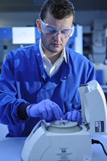 Scientist At Work Drucke: Scientist loading a centrifuge
