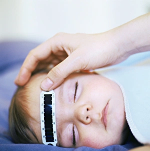 Drucke von MODELL FREIGEBEN. Die Babys-Temperatur nimmt man mit einem Thermometerstreifen ab, der bei Veränderungen des Körpertempers die Form ändert und Licht reflektiert Bilder Datiert 2007 Mai: Nehmen Sie das Kindermzimmer-Temperatur