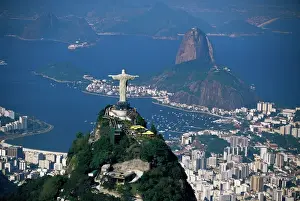 Drucke von Luftaufnahme einer Stadt mit der Statue des Christus der Barmherzigkeit im Vordergrund und dem Pão de Açúcar im Hintergrund aus Sicht über Rio de Janeiro Brasilien Südamerika Südamerikanische Kunstdrucke: Luftaufnahme einer Stadt mit dem Christus der Barmherzigkeit-Bildnis im Vordergrund
