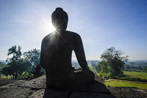 Buddha Statue Indonesia Drucke: Backlight of a sitting Buddha in the temple complex of Borobodur