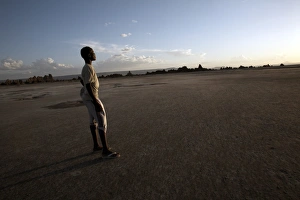 Africa Desert Scenery Drucke: A boy stands in the desolate landscape of Lac Abbe, Djibouti, Africa