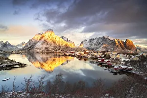 Norway Winter Scenery Drucke: Dramatic sky at dawn over Mount Olstind covered with snow, Reine Bay, Nordland