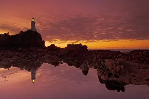 Corbiere Lighthouse Jersey Drucke: Dramatic sunset and low tide, Corbiere lighthouse, St. Ouens, Jersey, Channel Islands