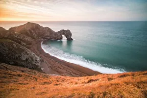 Die Durdle-Door am Sonnenaufgang in Lulworth Cove auf der Jurafuß-Gegirgsküste ist ein UNESCO-Welterbe