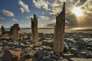 Sunset Over The Ocean UK Drucke: Groynes on the beach at Crow Point during sunset in Devon, Great Britain