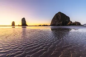 Oregon Coast Photography Drucke: Haystack Rock and The Needles at sunset, with textured sand in the foreground