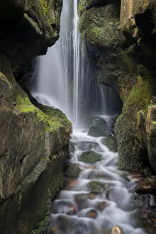 Bilder Datiert 25. Februar 2019: Versteckter Wasserfall hinter den Klippen am Singenden Sandstrand von Cleadale auf der Insel Eigg