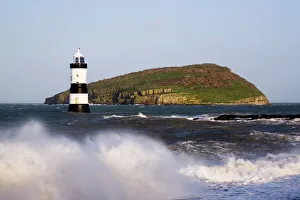 Drucke von Felsenkamm Fähreleuchtturm von Penmon Point Lighthouse aus dem Jahre 1838 am nördlichen Eingang zum Menai Strait und Puffins-Insel mit rauem Meer bei Hochwasser im Winter in Penmon auf der Insel Anglesey Drucke: Felsen von Penmon Leuchtturm