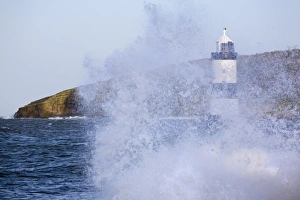 Drucke von Felsenpoint Leuchtturm von Penmon wurde 1838 an der nördlichen Eingangstelle des Menai-Straits gebaut und Puffins-Insel mit rauem Meer bei Hochwasser im Winter in Penmon auf der Insel Anglesey Verwandte Bilder Drucke: Felsenmanns Licht auf Penmon