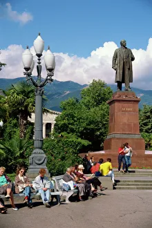 Drucke von Menschen sitzen auf Banken nahe einer Statue von Lenine in Jaltaschtraße im Krimkrautal der Ukraine und Europa Ukraine Drucke: Menschen sitzen auf Banken nahe einer Statue von Lenino in Jaltas
