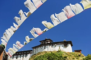 Buddhism In The Himalayas Drucke: Prayer flags below Wangdue Phodrang Dzong, founded by the Zhabdrung in 1638, Bhutan, Asia