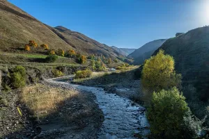 Dagestan Landscape Drucke: River flows through a valley featuring grass and trees in Dagestan, Russia