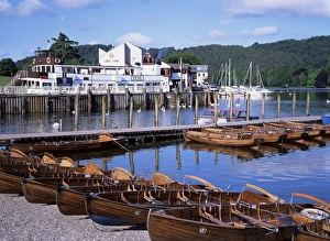 See Drucke: Ruderschiffe und Pier in Bowness-on-Windermere im Distrikt des Lake District in der Grafschaft Cumbria im Vereinigten