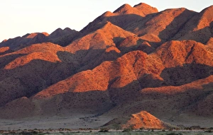 Peaceful Nature Scenery Drucke: Sandstone mountains lit by the last rays of light from the setting sun